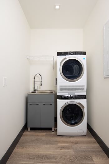A laundry room with a washer and dryer stacked on top of each other.